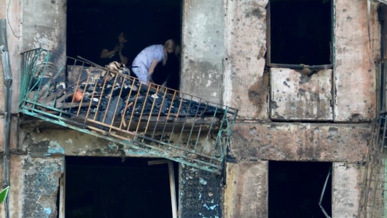 People pick through the debris of a bomb-struck building.