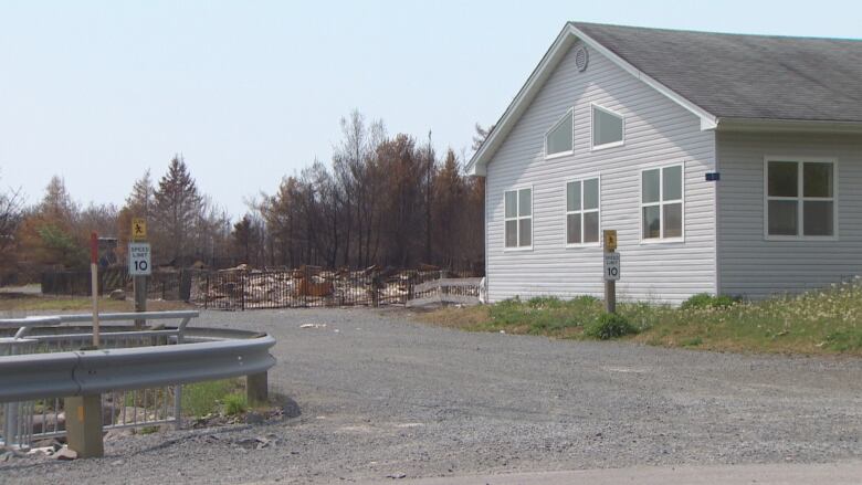 A destroyed building is fenced off right next to a building that appears undamaged.