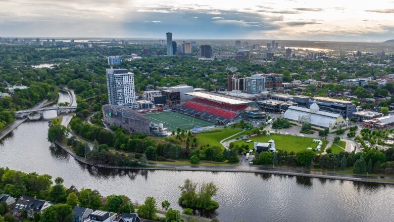 A park with a football stadium next to a canal.