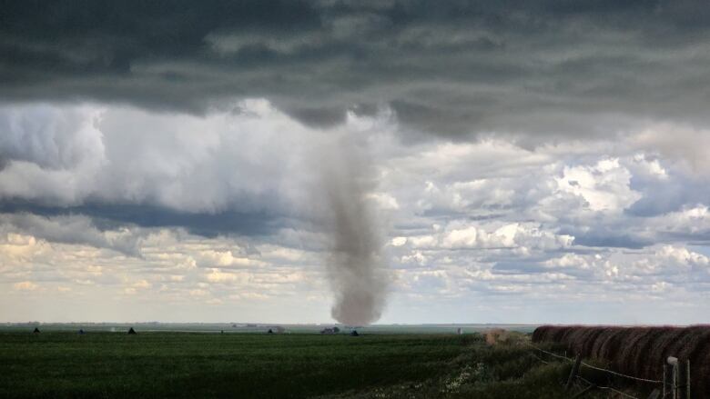 Clouds swirl in a sky as a tornado makes it way across Alberta.