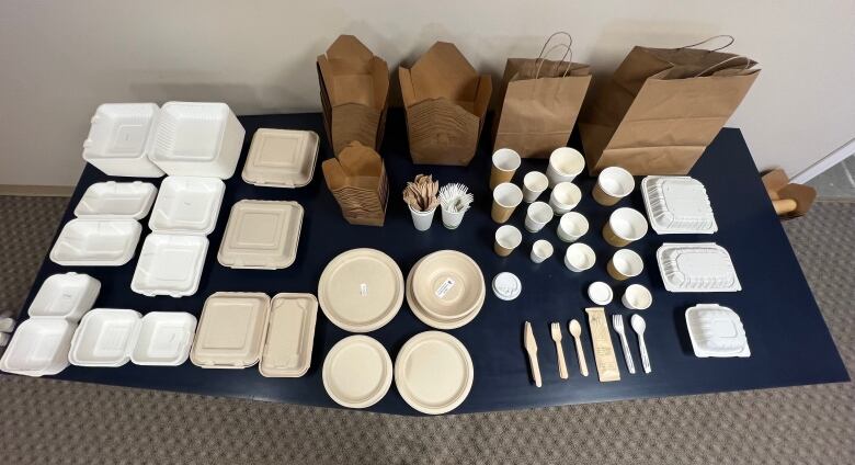 Food containers and bags sit on a table.