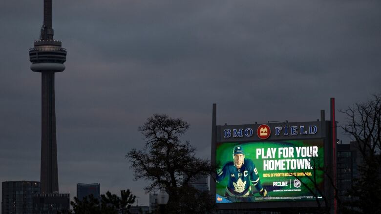 A billboard advertising sports gambling is pictured in front of the CN Tower.