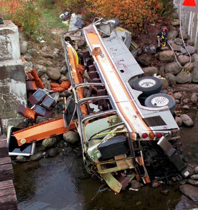  A severely damaged bus is seen on its side after it plunged into a ravine.