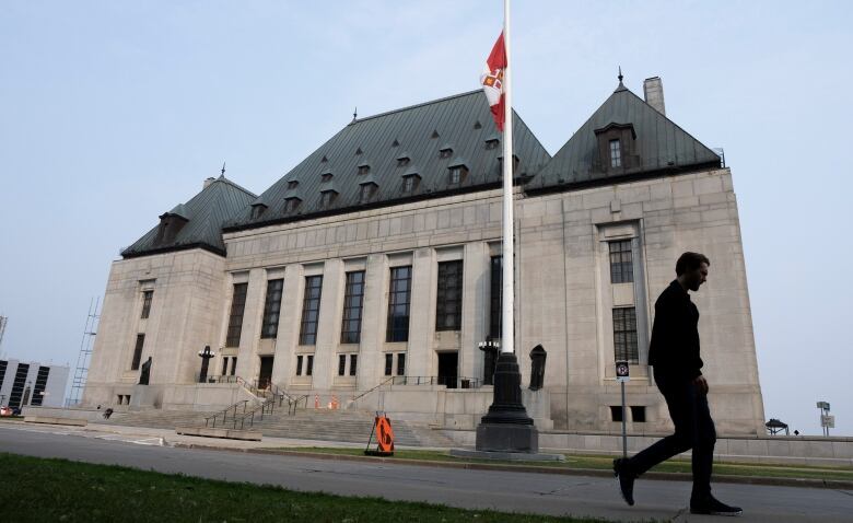 A man walks by the Supreme Court of Canada building in Ottawa.