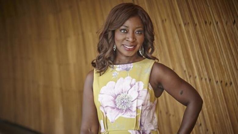 A lawyer wearing a yellow floral dress posing for a photo