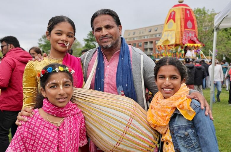 A man is shown smiling with his three daughters