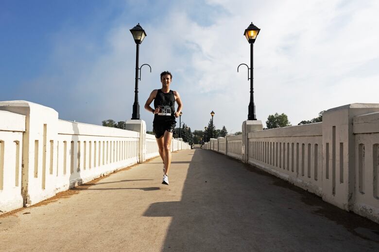 A man runs over a bridge.