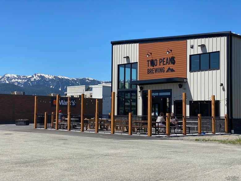 A brewing building sits in front of a mountain range.