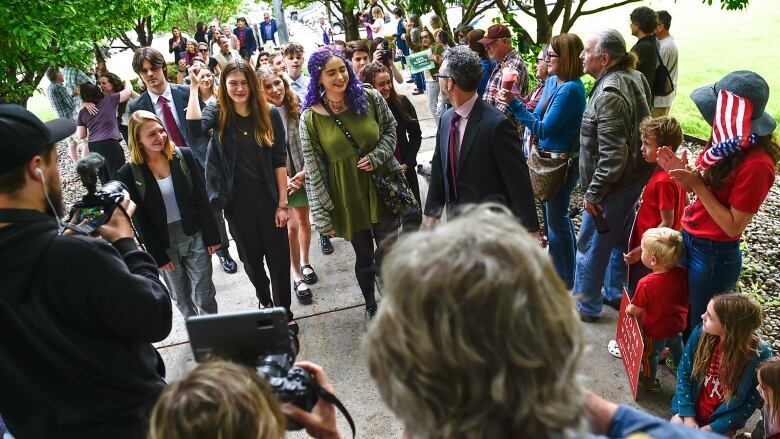 A group of young people walk toward the courthouse