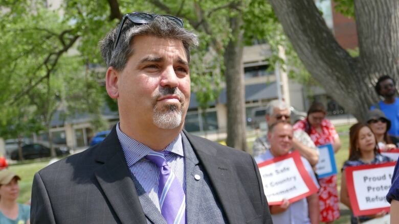 A man in a suit looks of into the distance 