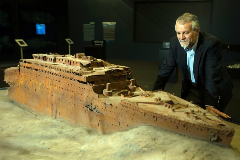 A man looks over a miniature version of the Titanic.