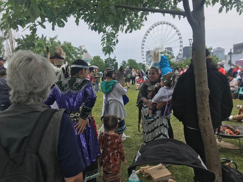 People are gathered outside on the grass.