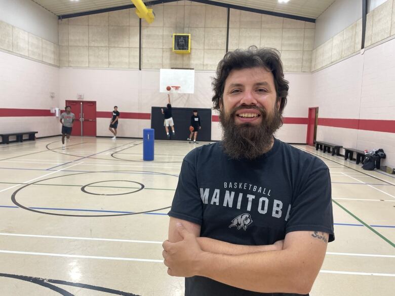 Head Coach Keith Mason smiles and the camera after saying he is feeling good and confident in his U19 men's basketball team. 