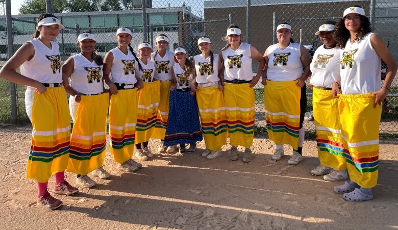 the U16 female softball team displays their hand made ribbon skirts proudly