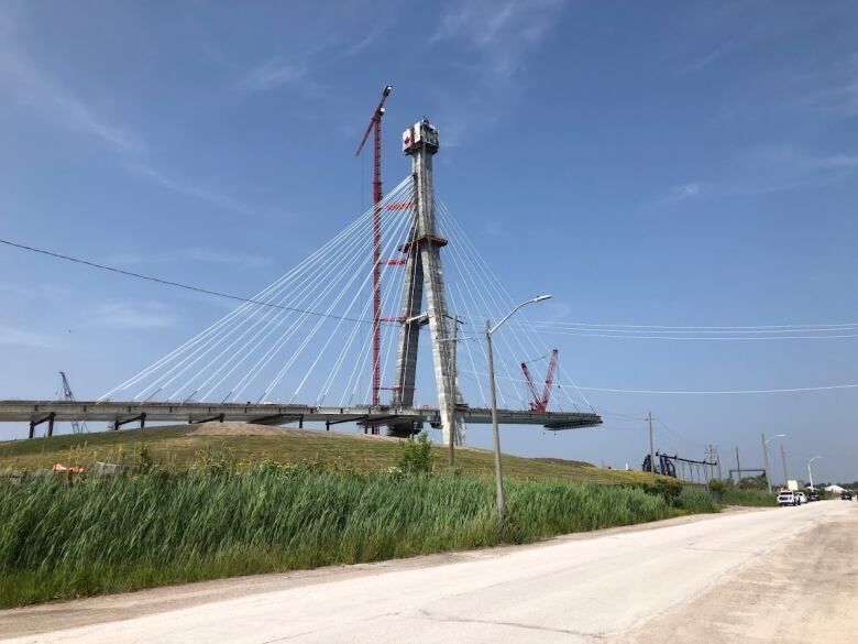 A crane working on a bridge that is not currently complete. 