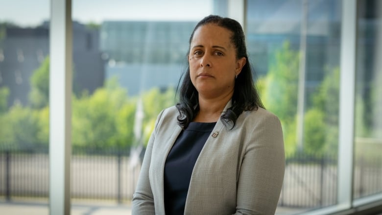 A woman in a suit poses for a photo.