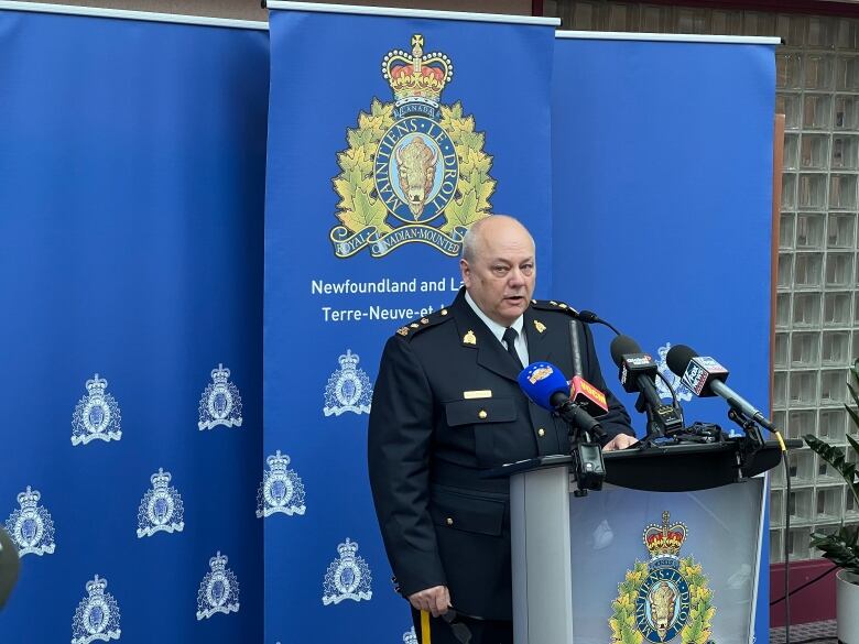 A police officer standing behind a mic.