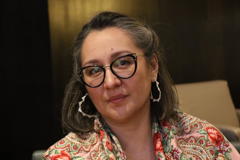 A Cree woman looks directly at the camera with a flowered shall.