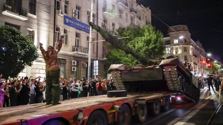 A tank is loaded onto an trailer.