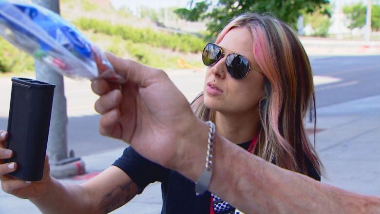 A woman hands out harm reduction items.