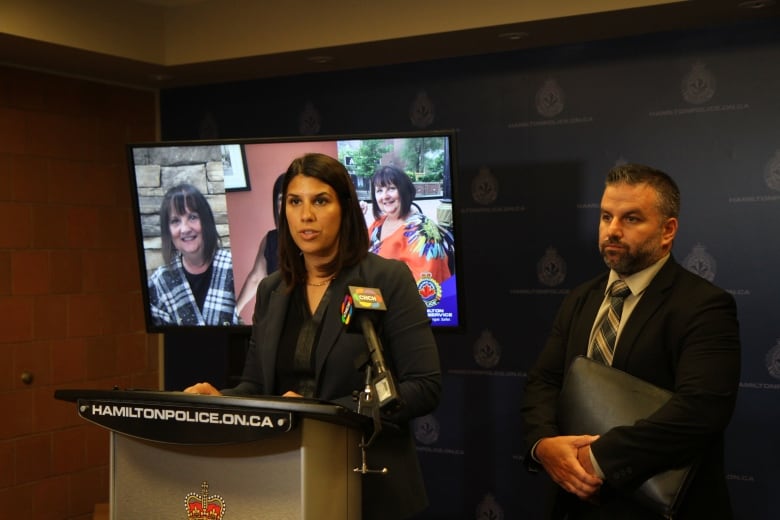 Police in front of a TV screen. 