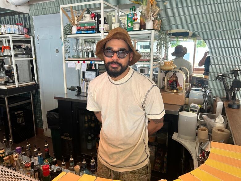 A man stands behind a bar at a restaurant