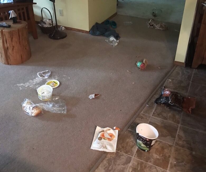 Some opened food packages are strewn about on the floor of a home.