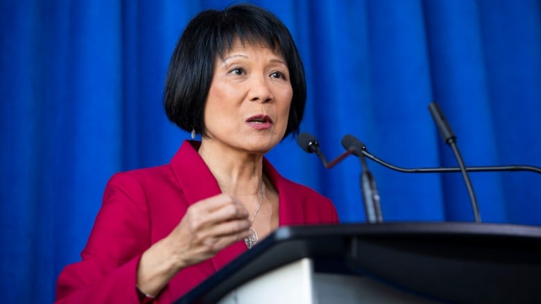 Portrait of Olivia Chow at a podium microphone. 