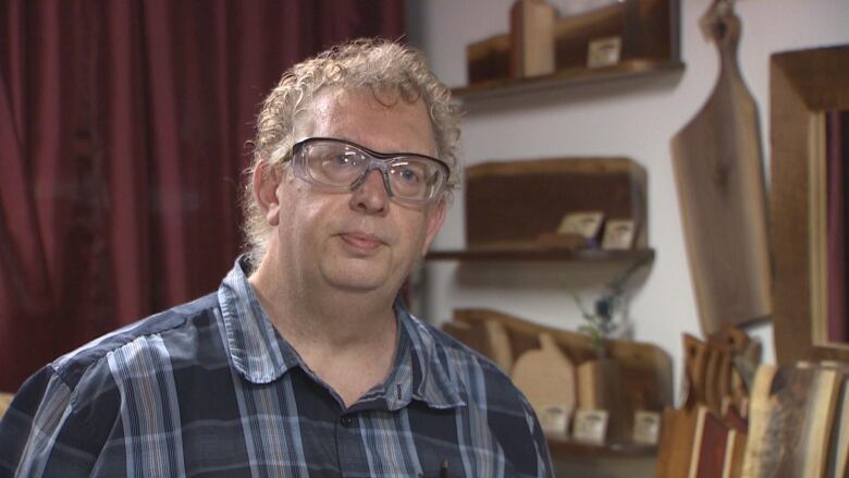 A woodworker wears safety glasses in his studio