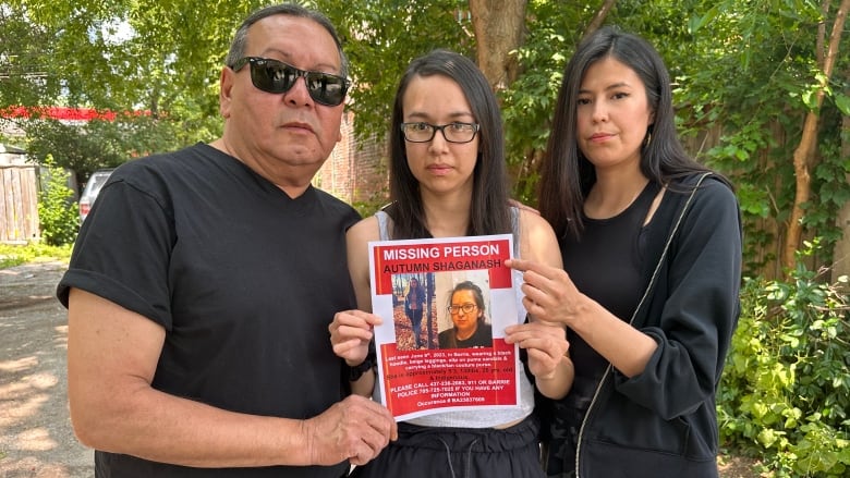 A family stands holding a missing poster for Autumn Shaganash