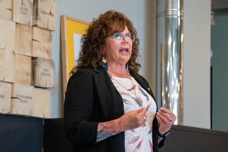 A woman makes a speech, standing.