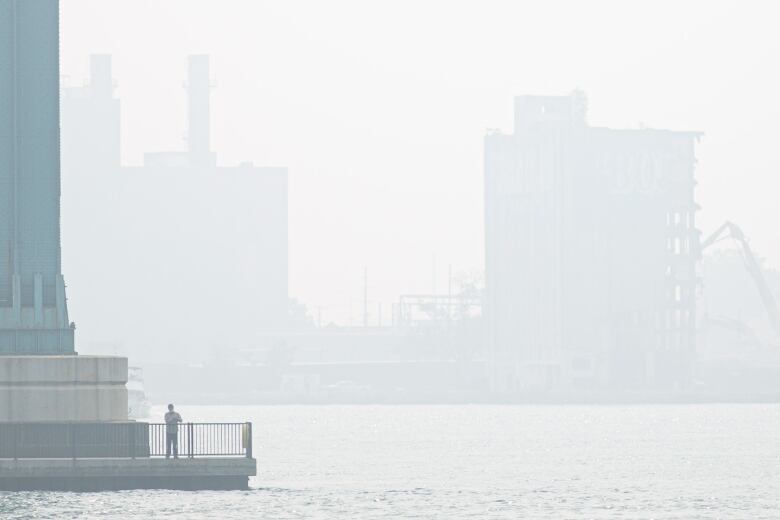 Pictured, a figure stands on a platform at the base of the Ambassador Bridge on Thursday, June 29, 2023. 