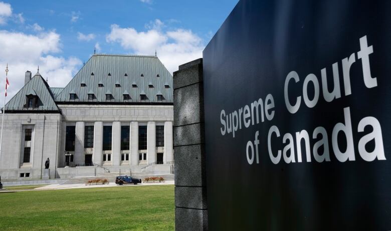 A sign for the Supreme Court of Canada is seen in front of the lawn of the courthouse in Ottawa.