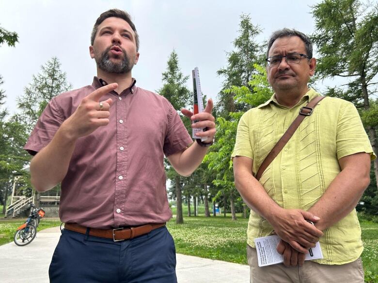 Two men stand in front of a crowd.