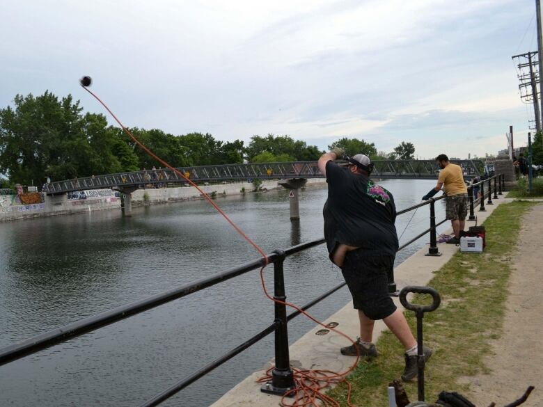 man tossing rope into water