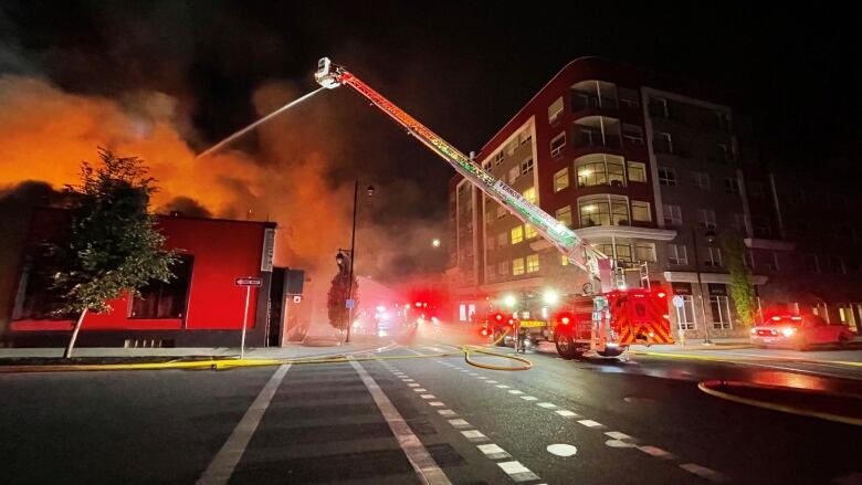 A fire truck crane is used to fight a fire