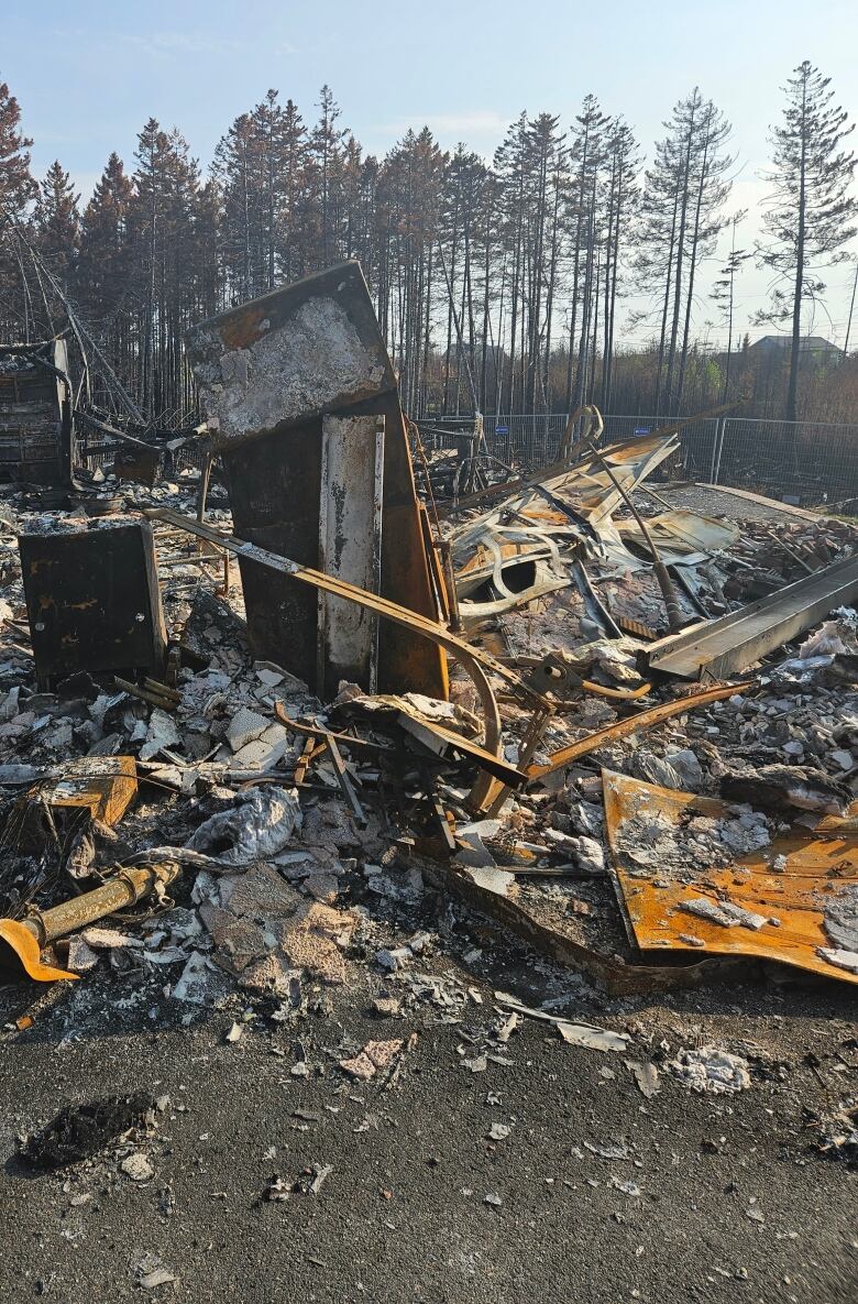 Charred rubble is seen where a home used to stand.