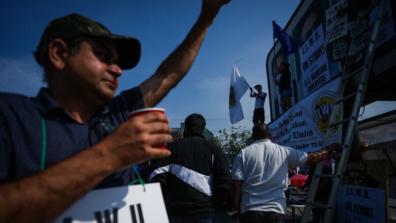 Striking port workers are pictured in the sun in Vancouver.