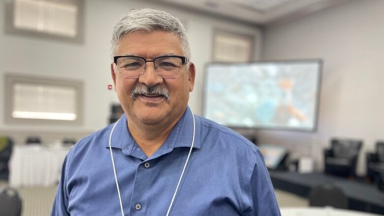 Man at conference smiles at camera.