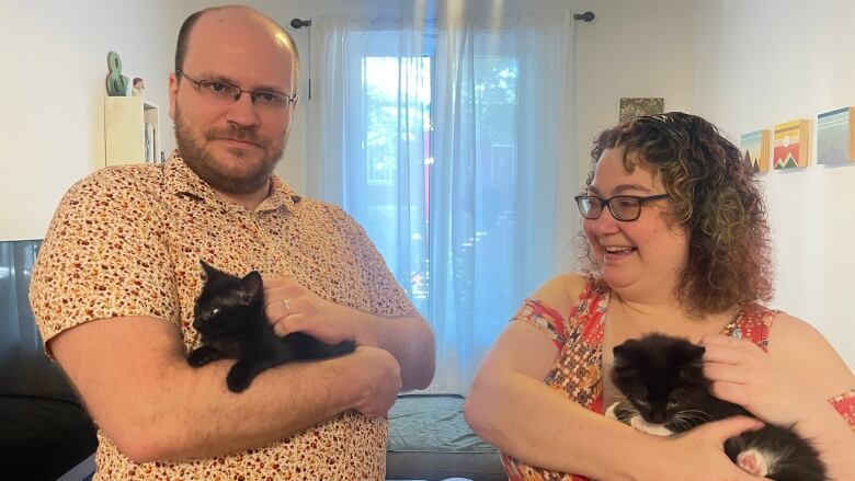 Meredith Baird and her partner holding their new fostered kittens.