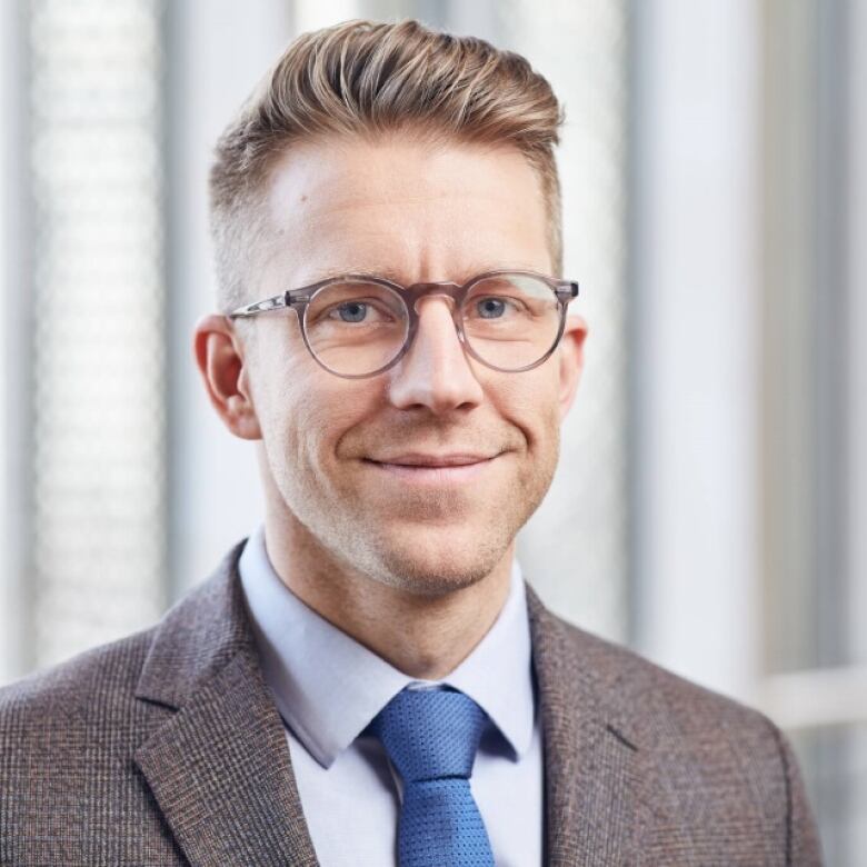 A portrait of a smiling man in a suit.