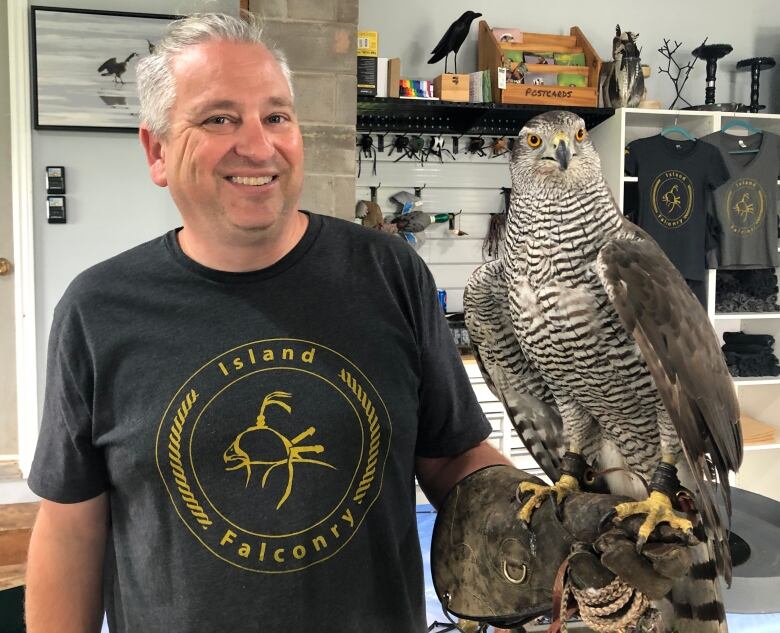 A man with a hawk perched on his left arm.