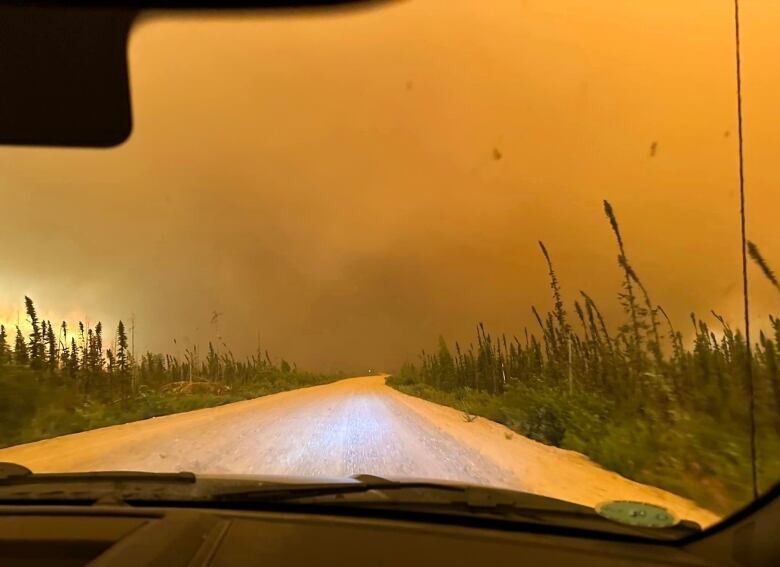 an orange sky darkens because of fire