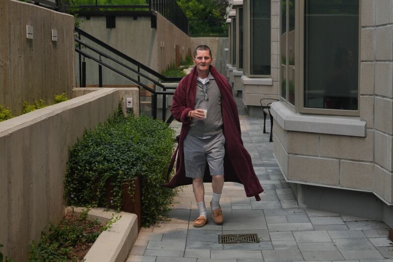 Kevin Ackroyd walks on the patio at Kensington Hospice, in Toronto, Tuesday, June 6, 2023. 