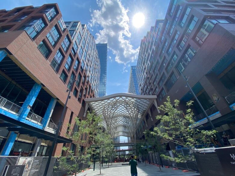 A path between residential buildings with a glass canopy. 