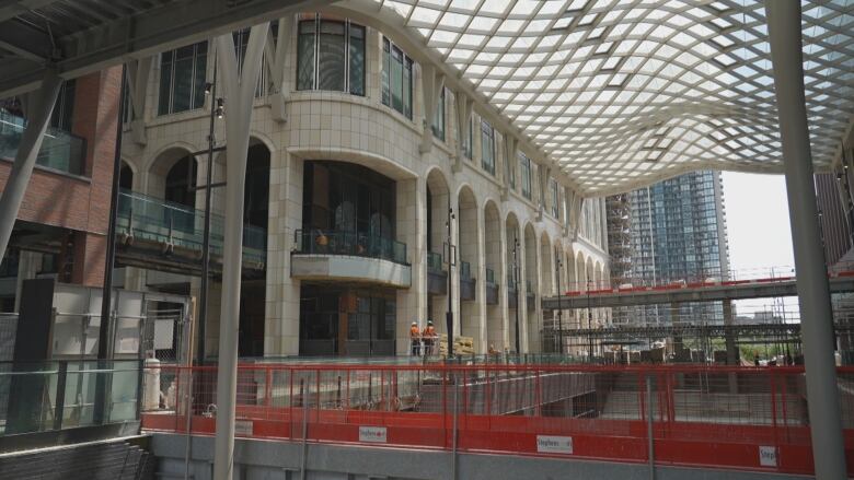 A shopping area, a building with white stone brick and construction bridges.