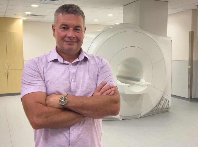 Marven MacLean posing in front of MRI machine.