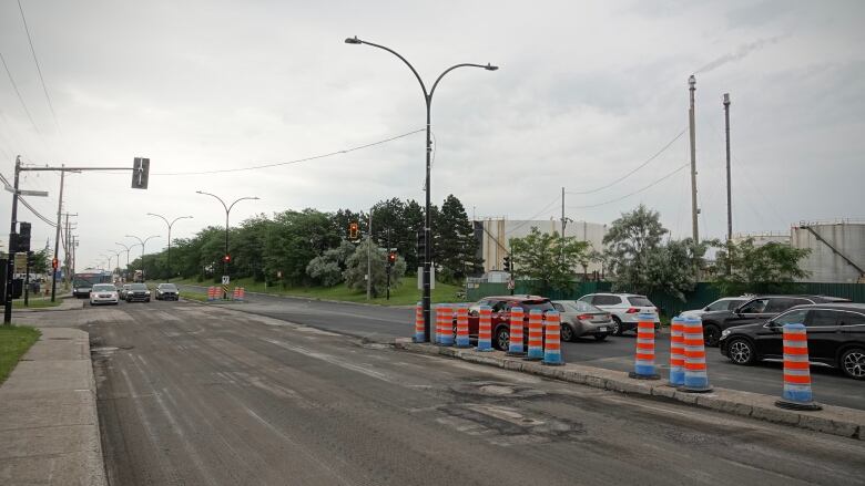 A road with orange cones. 