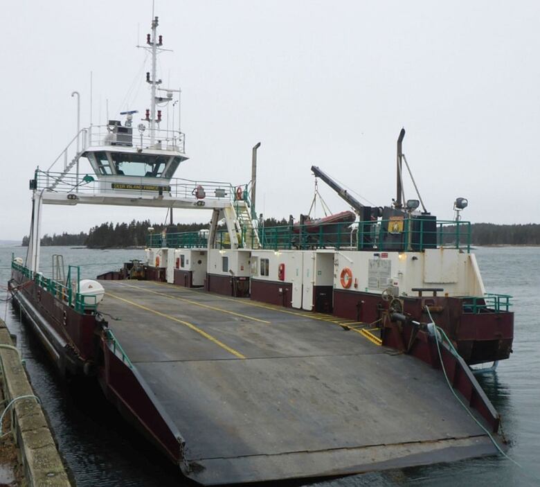 A docked red and white car ferry.