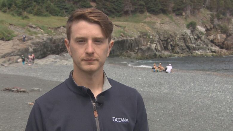 A man in a jacket at the beach.